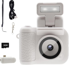 Compact white digital camera with LCD screen, includes 32GB card, charging base, USB cable, strap, and keychain attachment.