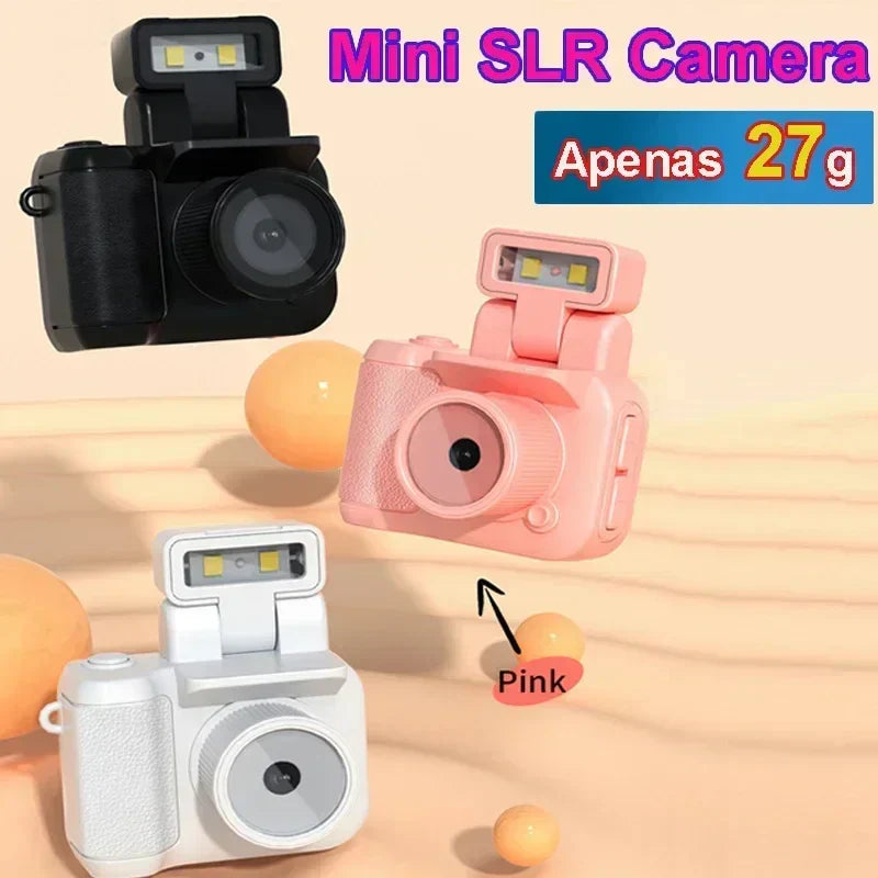 Mini SLR style keychain camera in black, pink, and white, featuring built-in flash.